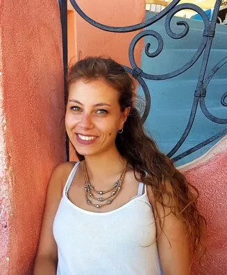 Lorenza Palazzo sorridente davanti a un muro arancione